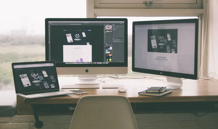 Puesto de diseño web con maquetas en pantalla